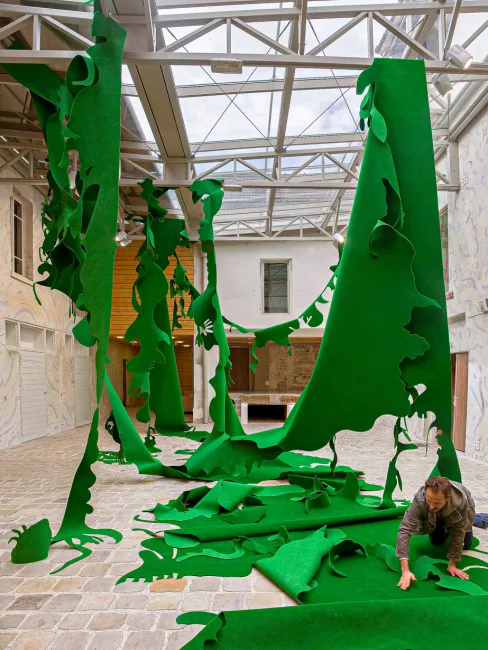 View Grenouille a monumental green felt cutout in space at La Graineterie Art Center in Houilles
