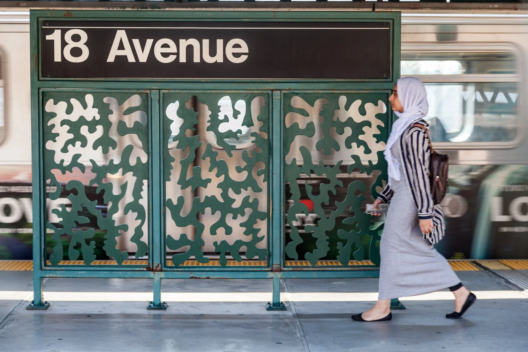 Sculptural bench and windscreen made of a single plate of stainless steel cut along a single line and folded presenting two figures inspired by contemporary and historical figures, in an elevated subway platform in New YOrk