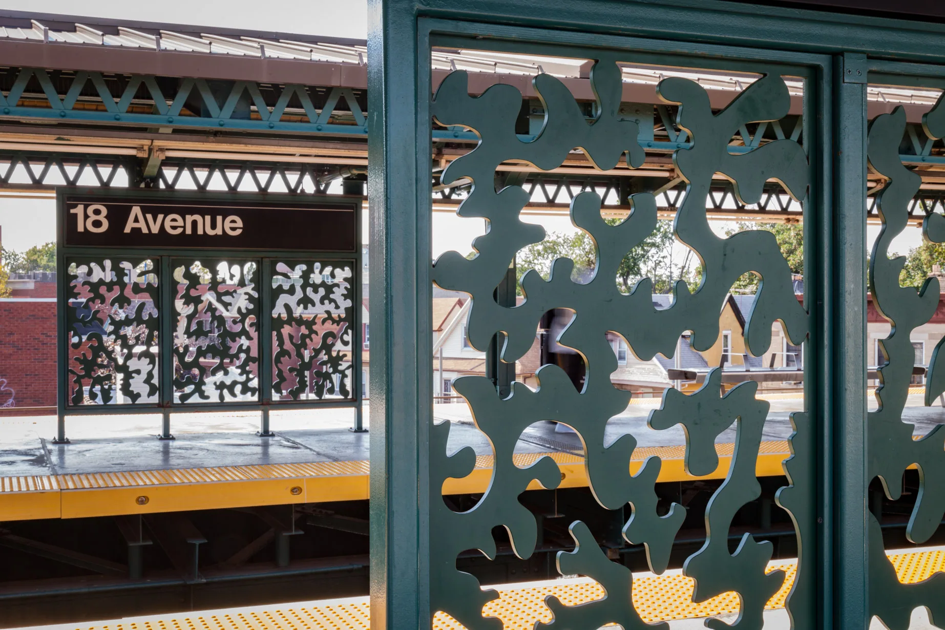 Sculptural bench and windscreen made of a single plate of stainless steel cut along a single line and folded presenting two figures inspired by contemporary and historical figures, in an elevated subway platform in New YOrk